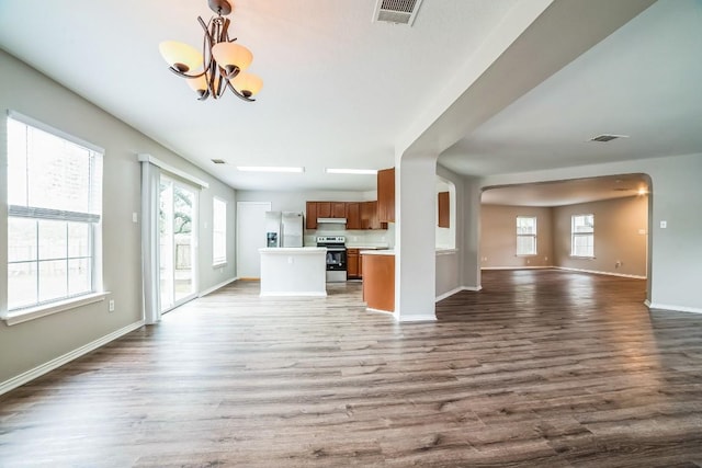 unfurnished living room with hardwood / wood-style floors and a notable chandelier