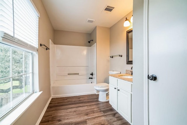 full bathroom featuring toilet, plenty of natural light, vanity, and hardwood / wood-style flooring