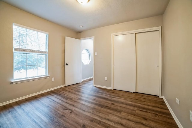 unfurnished bedroom featuring dark hardwood / wood-style flooring and a closet