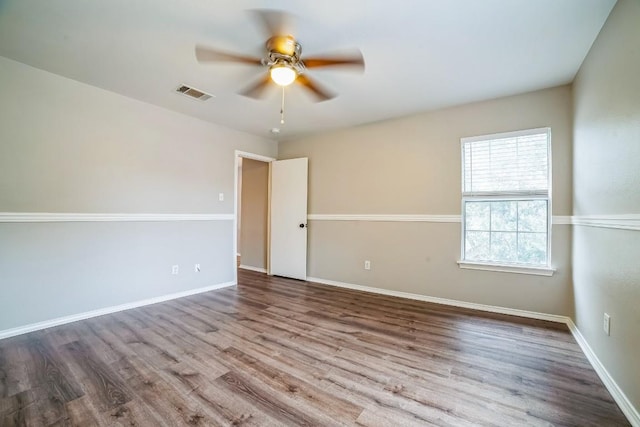 empty room with hardwood / wood-style floors and ceiling fan