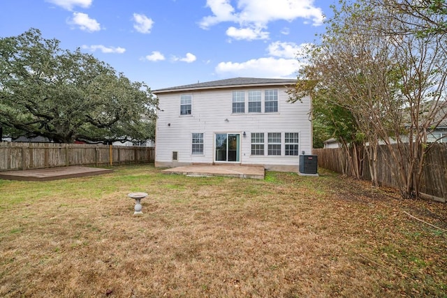 rear view of property with a yard, cooling unit, and a patio