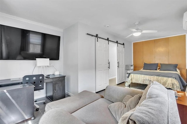 bedroom featuring wood-type flooring, a barn door, ceiling fan, and crown molding