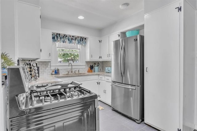 kitchen with white cabinets, stainless steel appliances, and tasteful backsplash