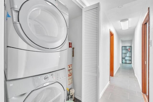 washroom featuring light tile patterned flooring and stacked washing maching and dryer