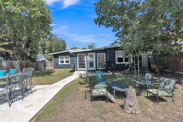 rear view of property with a lawn and a patio