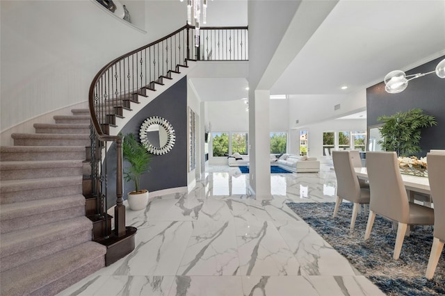 entrance foyer with a towering ceiling and crown molding