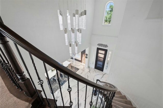 stairway with carpet floors and a high ceiling