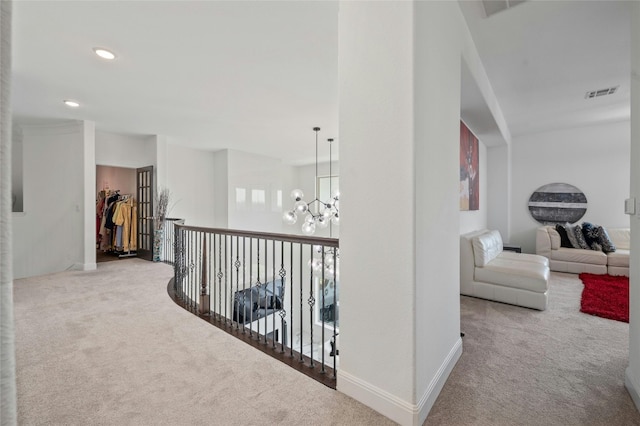 corridor with carpet floors and an inviting chandelier