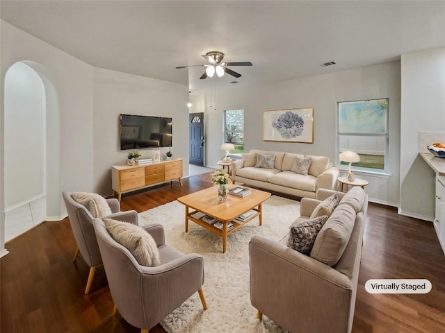 living room featuring ceiling fan and dark wood-type flooring