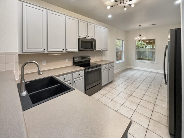 kitchen featuring pendant lighting, a chandelier, sink, and black appliances