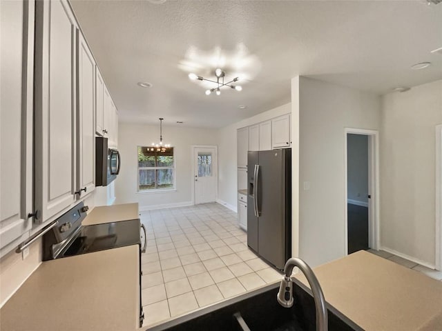 kitchen with white cabinets, light tile patterned floors, pendant lighting, a chandelier, and stainless steel fridge with ice dispenser