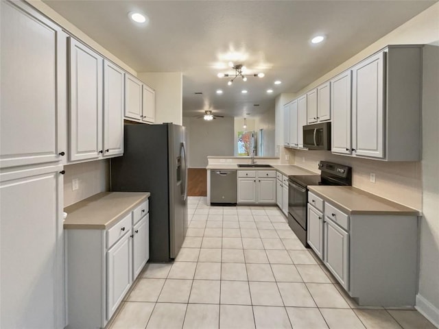 kitchen featuring sink, light tile patterned floors, ceiling fan with notable chandelier, and appliances with stainless steel finishes