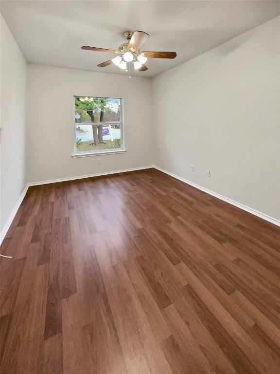 spare room featuring dark hardwood / wood-style floors and ceiling fan