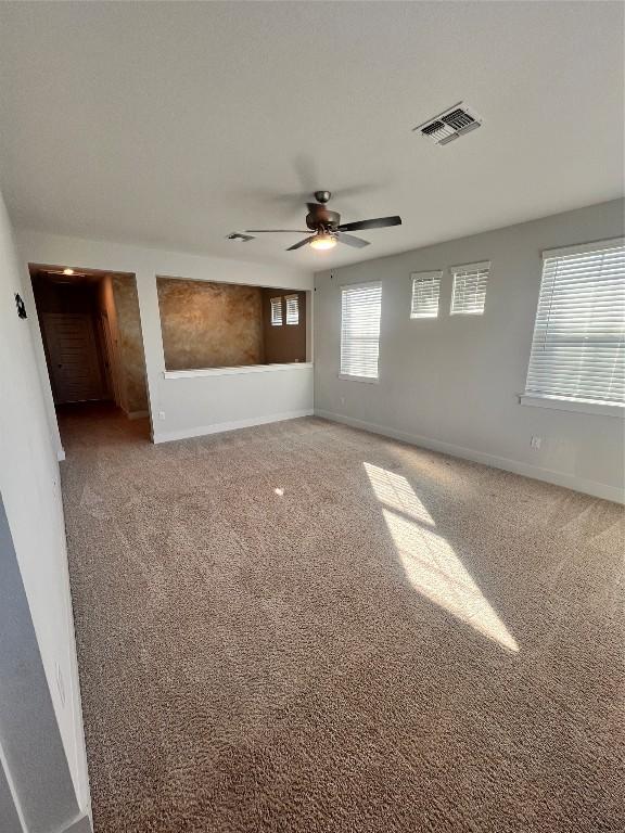 carpeted spare room with ceiling fan