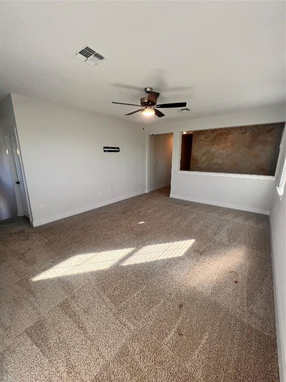 carpeted spare room featuring ceiling fan