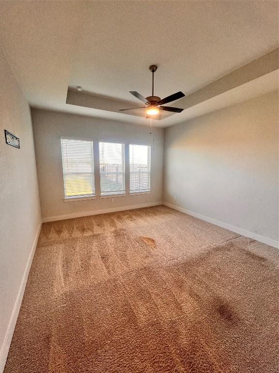 carpeted spare room featuring a textured ceiling, plenty of natural light, and ceiling fan