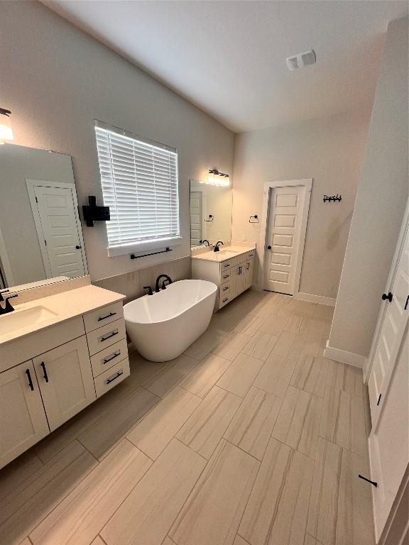 bathroom featuring vanity and a tub