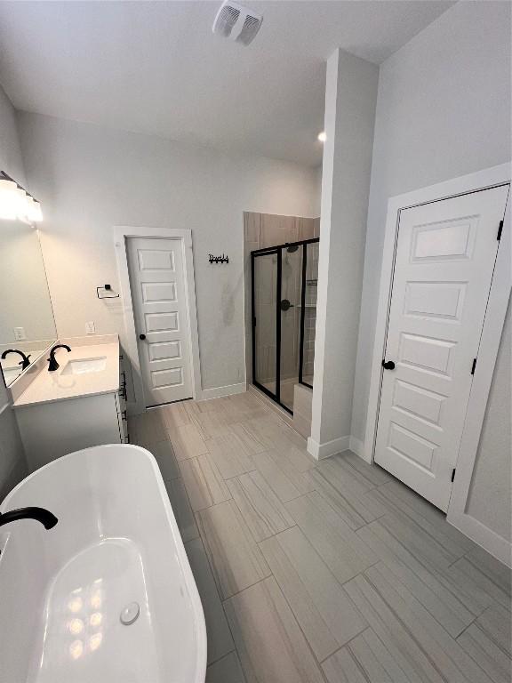 bathroom featuring vanity and separate shower and tub