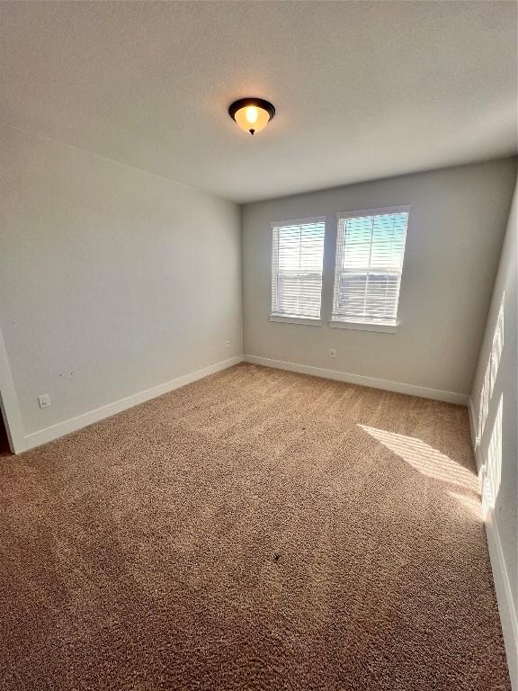 carpeted spare room with a textured ceiling