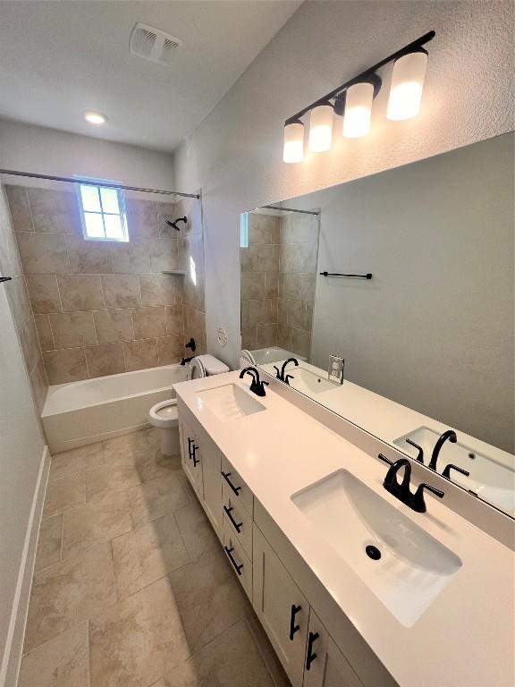 full bathroom with vanity, toilet, and tiled shower / bath combo