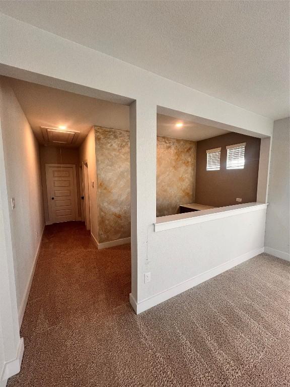 hallway featuring a textured ceiling and carpet floors