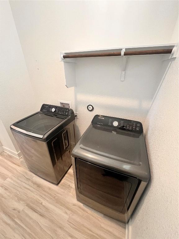 interior space featuring washing machine and clothes dryer and light wood-type flooring