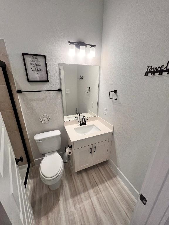 bathroom featuring hardwood / wood-style flooring, vanity, and toilet