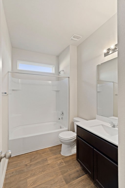 full bathroom featuring vanity, hardwood / wood-style floors, shower / bathing tub combination, and toilet