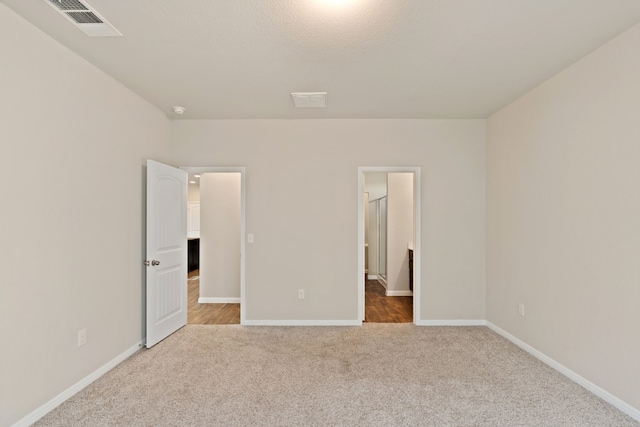 unfurnished bedroom featuring light carpet