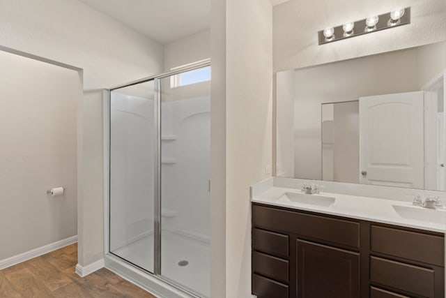 bathroom with hardwood / wood-style floors, vanity, and a shower with shower door