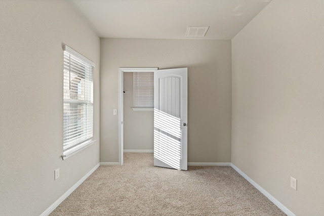 spare room featuring light carpet