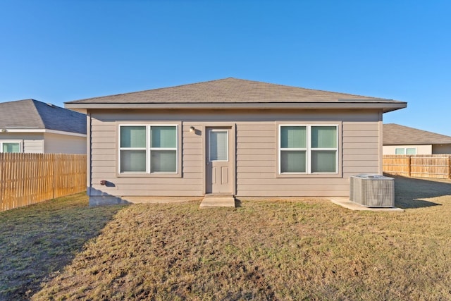 view of front of house with a front lawn and central AC unit