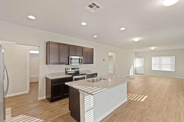 kitchen featuring light hardwood / wood-style flooring, an island with sink, stainless steel appliances, and sink