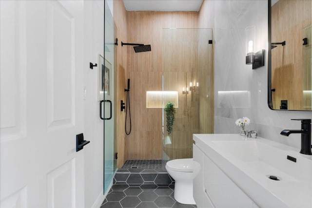 bathroom featuring tile patterned flooring, vanity, toilet, and an enclosed shower