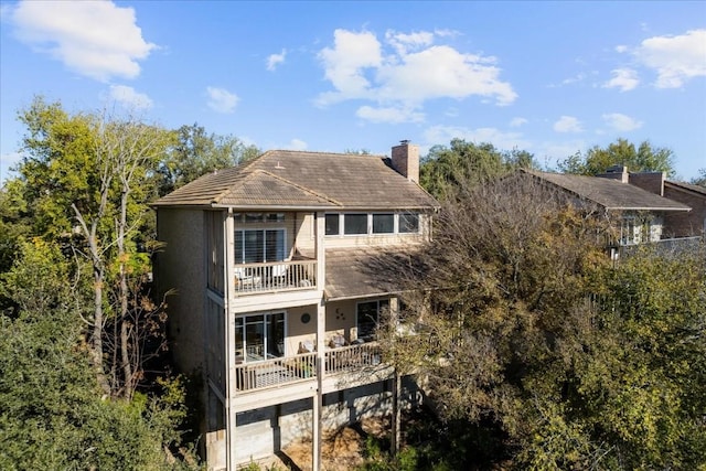 back of house featuring a balcony and a garage