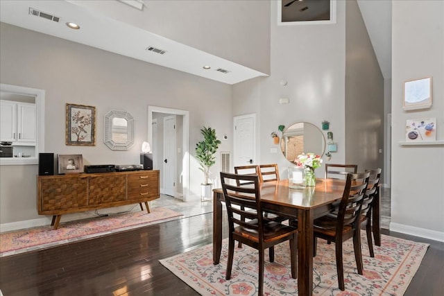 dining room featuring wood-type flooring and high vaulted ceiling