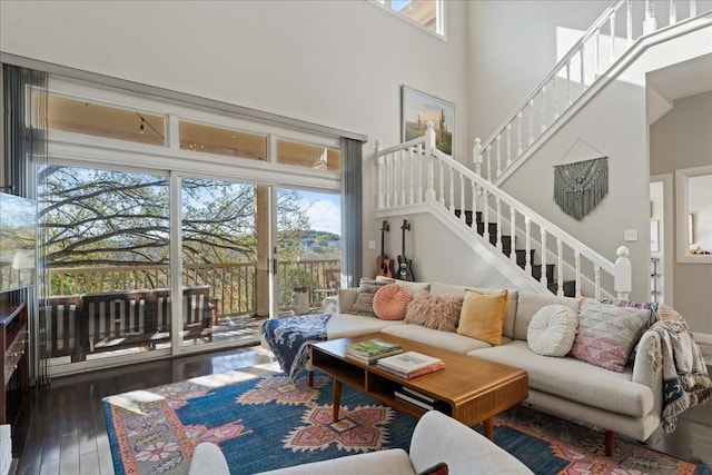 living room featuring a wealth of natural light, dark wood-type flooring, and a high ceiling