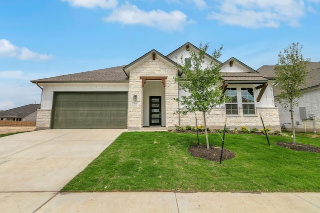view of front of property featuring stone siding, a garage, a front lawn, driveway, and roof with shingles