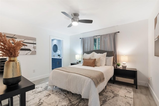 bedroom featuring light wood-type flooring, ensuite bathroom, and ceiling fan