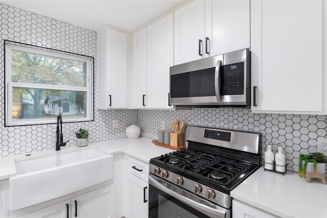 kitchen with white cabinets, appliances with stainless steel finishes, and sink