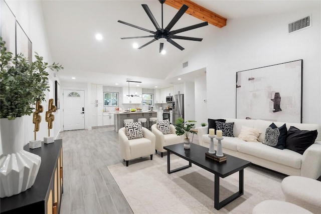 living room featuring ceiling fan, light hardwood / wood-style flooring, beamed ceiling, and high vaulted ceiling