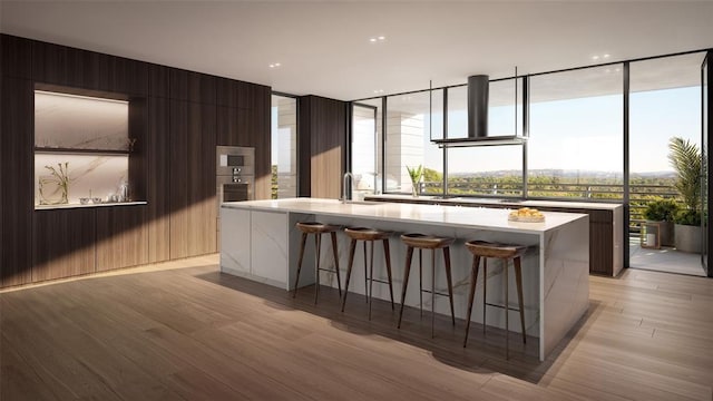 kitchen with a kitchen bar, a large island, sink, and light hardwood / wood-style floors