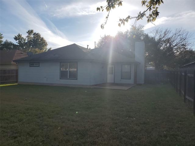 back of property featuring a lawn and a patio