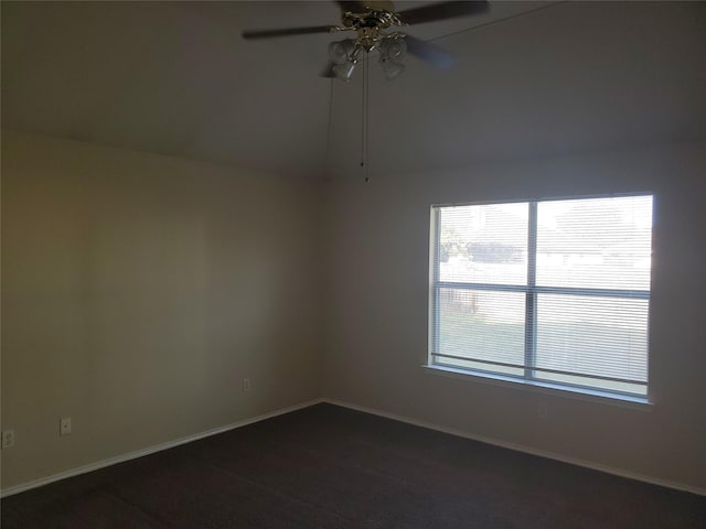 unfurnished room featuring ceiling fan and dark carpet