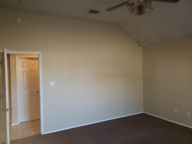 spare room featuring vaulted ceiling, light tile patterned flooring, and ceiling fan