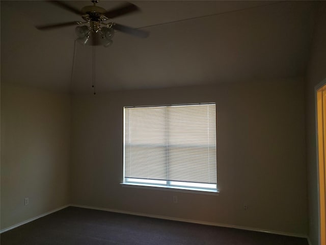 spare room with ceiling fan and dark carpet