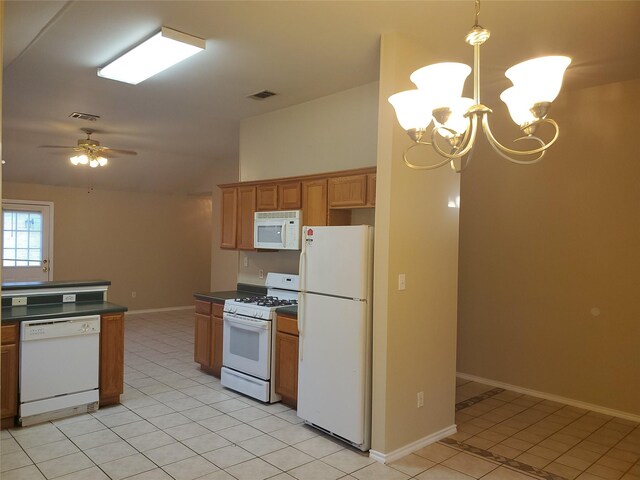 kitchen featuring white appliances, light tile patterned floors, hanging light fixtures, and ceiling fan with notable chandelier