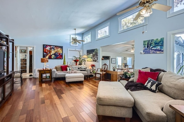 living room featuring high vaulted ceiling, wood-type flooring, and a wealth of natural light