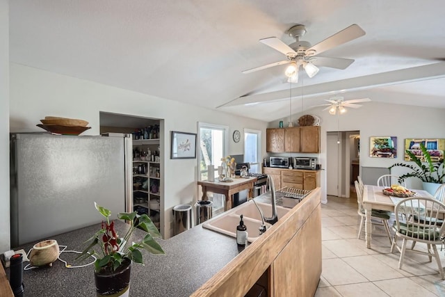 kitchen with ceiling fan, sink, white fridge, vaulted ceiling, and light tile patterned floors