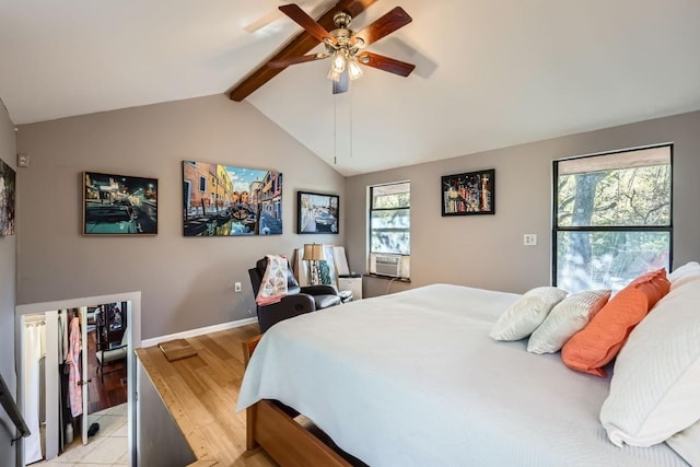 bedroom featuring vaulted ceiling with beams, ceiling fan, light wood-type flooring, and multiple windows